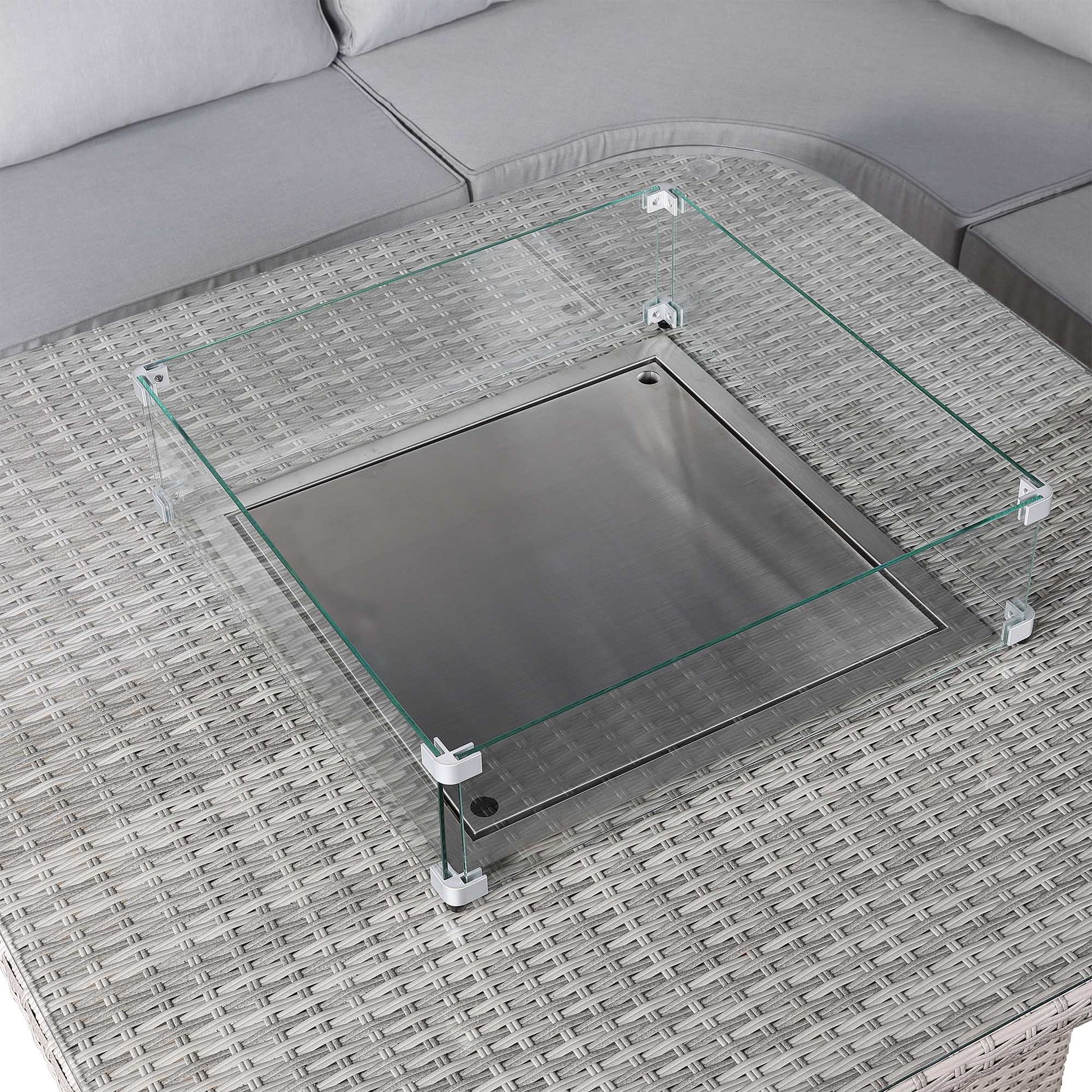 Glass coffee table on a textured surface with a sofa in the background