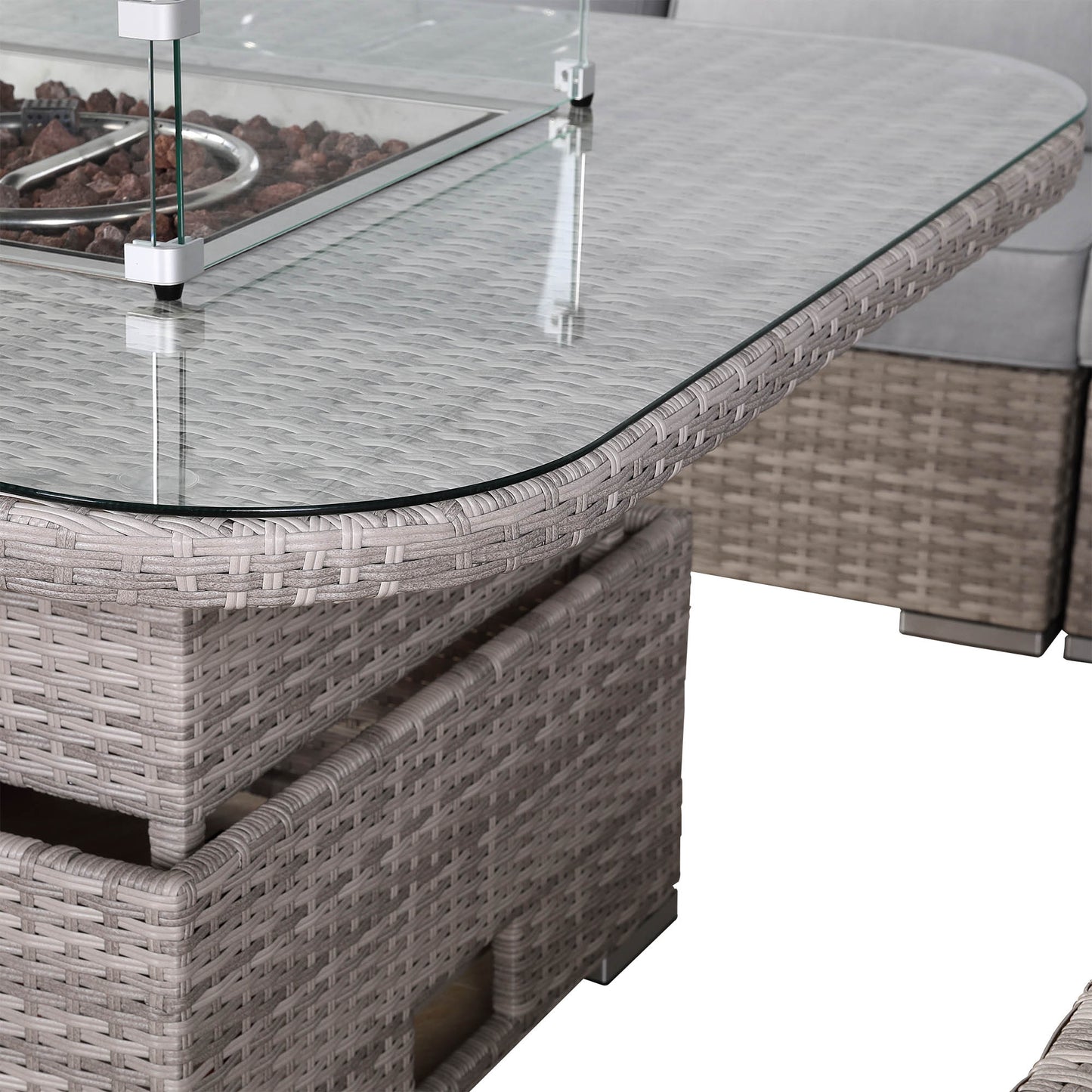 Glass-top outdoor dining table with wicker base on a white background